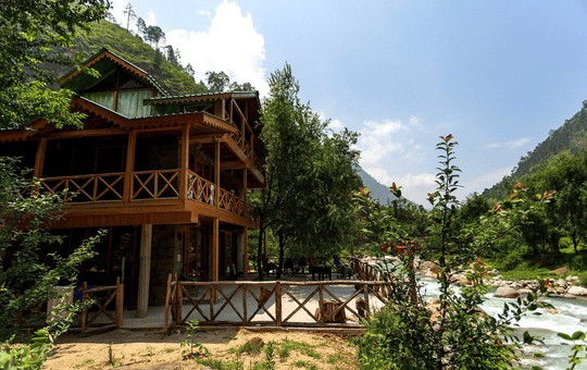 A Riverside Cottage Amidst Lush Greens Of Tirthan Valley Image