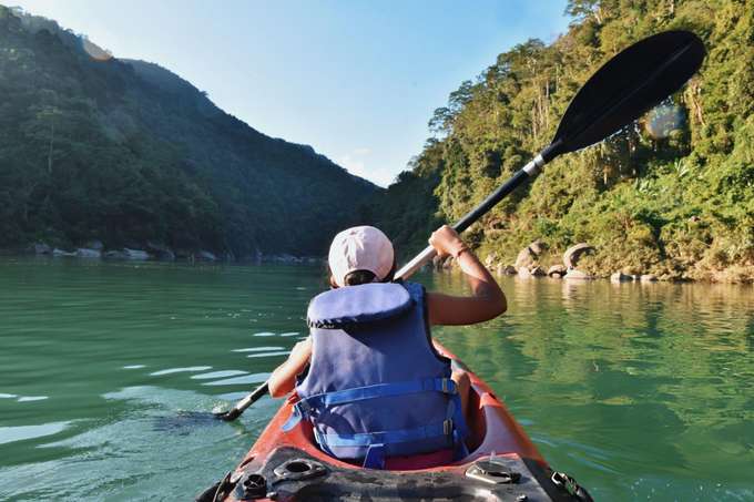 Paddle through paradise surrounded by green hills and cliffs