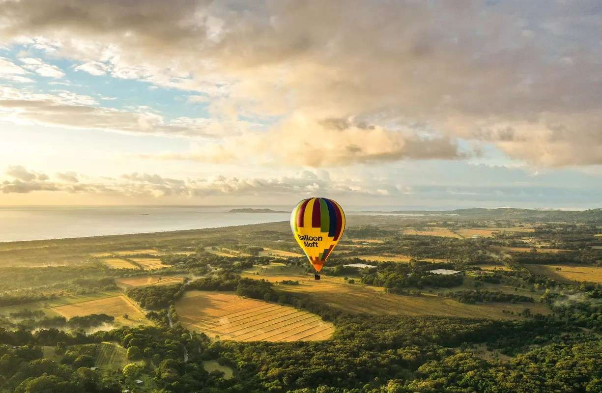 Soar over Byron Bay as the sun paints the sky in gold.