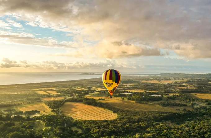 Soar over Byron Bay as the sun paints the sky in gold.