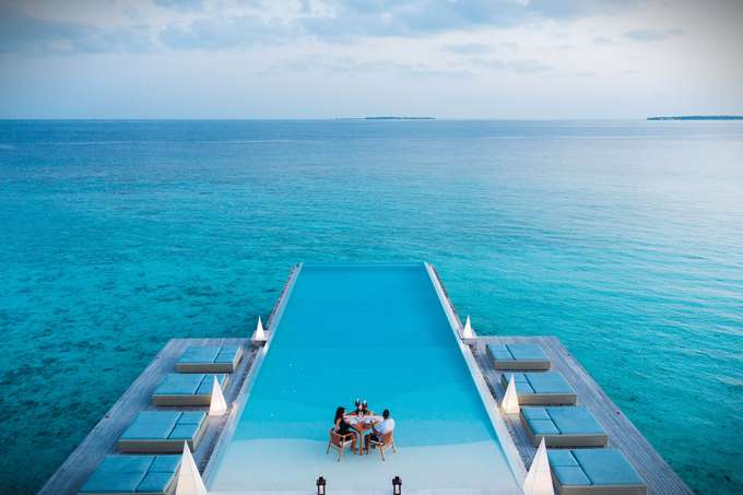Couple having drinks at Undaras Overwater Infinity Pool Bar