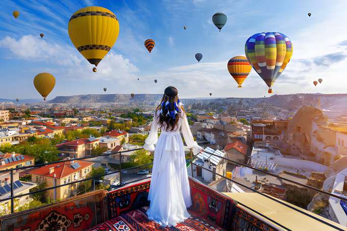 Girl looking to hot air balloons in Cappadocia, Turkey.