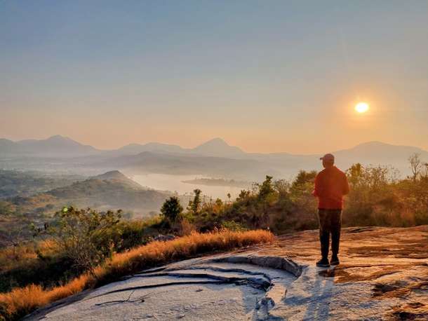 Witness the golden hues of dawn atop Makalidurga Hill for an unforgettable start to your day.