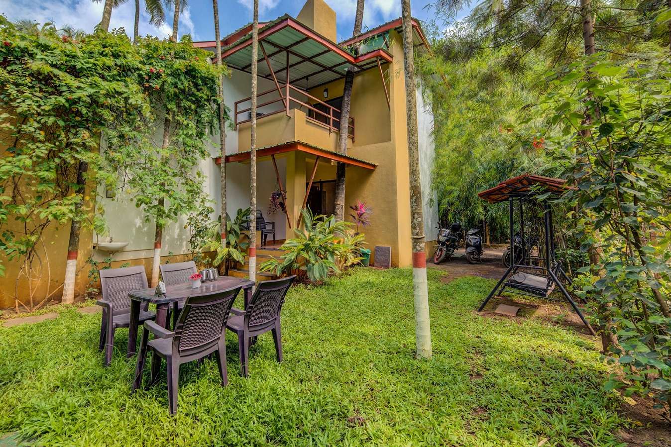 Lush green lawn of the homestay housed with a seating setup