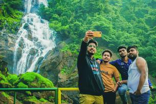 Visitors clicking pictures against the backdrop of Dudhsagar Falls 
