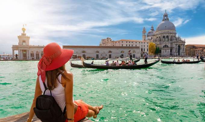 Glide through Venice’s canals on a gondola, passing historic palaces