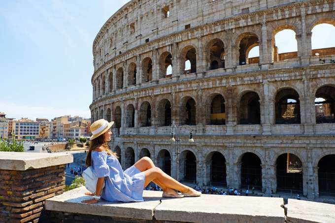 Tourist posing in front of the Colosseum, Rome