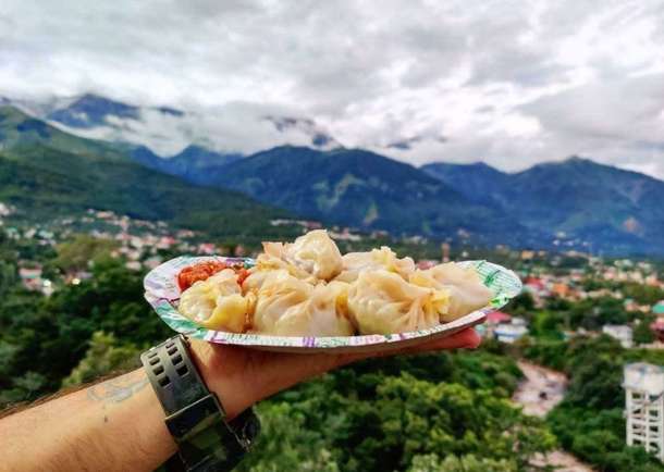 Savor the steamy delight of Tibetan momos while enjoying the breathtaking views